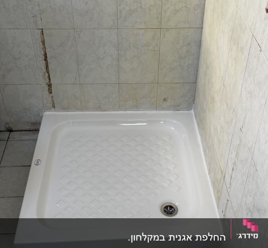 מקלחת עם אריחים לבנים וקירות מתקלפים